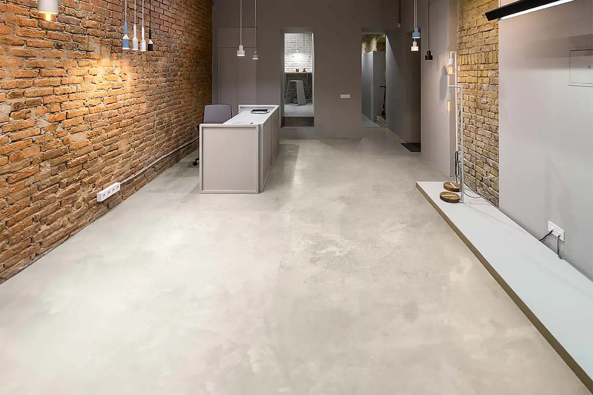 Industrieel kantoorinterieur met microcement vloer en bakstenen muur