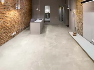 Industrieel kantoorinterieur met microcement vloer en bakstenen muur